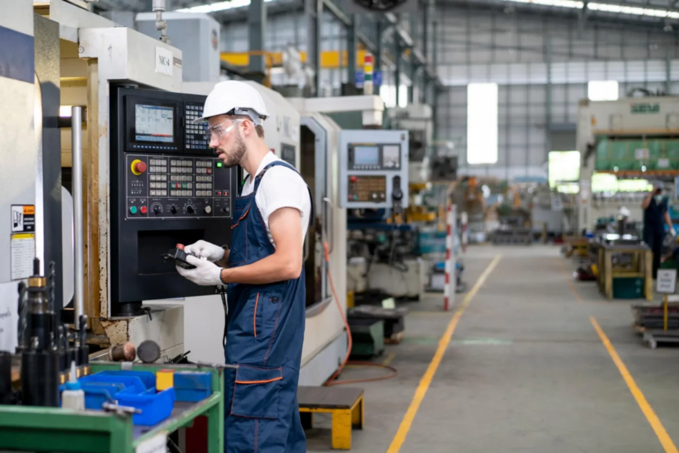 Tecnico al lavoro su un macchinario a controllo numerico in uno stabilimento industriale